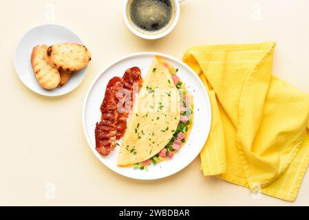 Omelette farcite con prosciutto e cipolla verde, tazza di caffè e pane tostato su sfondo chiaro. Pasto gustoso e salutare per colazione. Vista dall'alto, base piatta Foto Stock