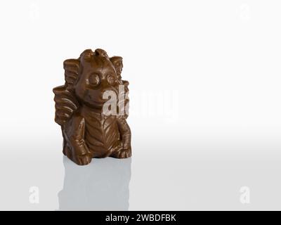 Drago di cioccolato al latte simbolo del 2024 secondo il calendario cinese isolato su sfondo bianco con riflesso Foto Stock