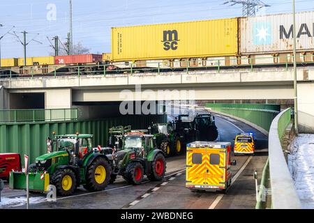 Bremerhaven, Germania. 10 gennaio 2024. I contadini sgomberano le strade di accesso bloccate al terminal container di Bremerhaven per i servizi di emergenza. Secondo la società di gestione portuale Bremenports, gli agricoltori stanno ostacolando il funzionamento del terminal container con il blocco del traffico. In risposta ai piani di austerità del governo federale, l'associazione degli agricoltori ha chiesto una settimana di azione con raduni e raduni a partire dall'8 gennaio. Crediti: Sina Schuldt/dpa/Alamy Live News Foto Stock