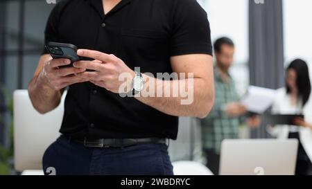 Gadget moderno. Primo piano dello schermo di uno smartphone nelle mani di un uomo d'affari. Foto Stock