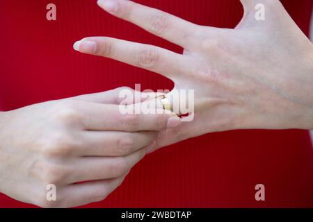 Primo piano di una donna che rimuove la sua fede nuziale Foto Stock