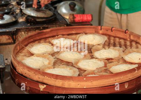 Serabi Notosuman appena fatto, tradizionale pancake giavanese. Su vassoio bambù Foto Stock