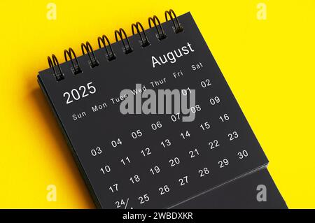 Agosto 2025 calendario da tavolo bianco e nero su sfondo giallo di copertina. Concetto di calendario. Foto Stock