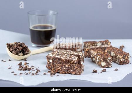 Dresda, Germania. 6 gennaio 2024. Le barre dei data di anacardi si trovano sulla carta da forno davanti a un bicchiere di caffè. Credito: Sebastian Kahnert/dpa/Alamy Live News Foto Stock