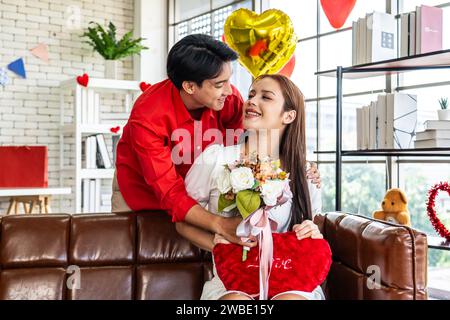 Un giovane che presenta un bouquet di fiori a una bella donna Foto Stock