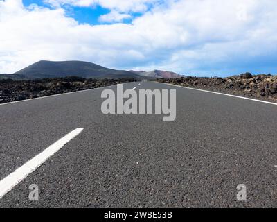 Vista panoramica della strada asfaltata vuota LZ-67 nel paesaggio vulcanico del Parco Nazionale di Timanfaya, Lanzarote, Isole Canarie, Spagna, Europa Foto Stock