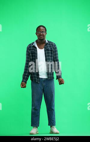 Un uomo con una camicia su sfondo verde è deluso Foto Stock