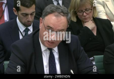 Cattura dello schermo dalla TV del Parlamento del Governatore della Banca d'Inghilterra Andrew Bailey parlando al Treasury Select Committee presso la Houses of Parliament di Londra, sulla minaccia alla stabilità finanziaria rappresentata dall'aumento dei tassi di interesse. Data foto: Mercoledì 10 gennaio 2024. Foto Stock