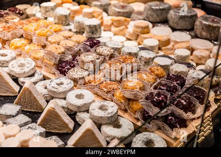 Lione, Francia - 30 GENNAIO 2022: Formaggio tradizionale francese venduto a Les Halles de Lyon Paul Bocuse, costruito nel 1971 nel 3° arrondissement di Lione, Auverg Foto Stock