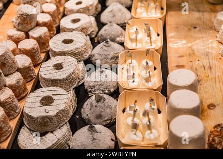 Lione, Francia - 30 GENNAIO 2022: Formaggio tradizionale francese venduto a Les Halles de Lyon Paul Bocuse, costruito nel 1971 nel 3° arrondissement di Lione, Auverg Foto Stock