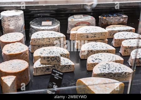 Lione, Francia - 30 GENNAIO 2022: Formaggio tradizionale francese venduto a Les Halles de Lyon Paul Bocuse, costruito nel 1971 nel 3° arrondissement di Lione, Auverg Foto Stock