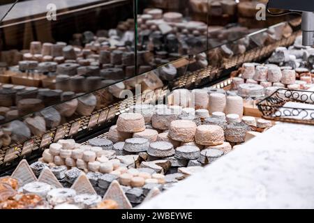 Lione, Francia - 30 GENNAIO 2022: Formaggio tradizionale francese venduto a Les Halles de Lyon Paul Bocuse, costruito nel 1971 nel 3° arrondissement di Lione, Auverg Foto Stock