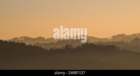 Paesaggio con molti strati di colline e montagne ricoperte di nebbia durante il tramonto. repubblica Ceca natura in campagna. Inverno. Foto Stock