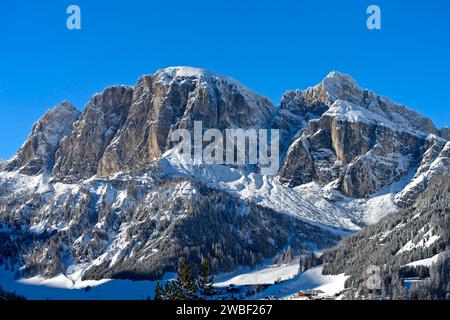 Cima innevata Sass de Ciampac sopra il paese di montagna di Colfosco, Colfosco, località di sport invernali alta Badia, Dolomiti, alto Adige, Italia Foto Stock