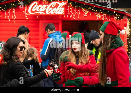 Belgrado, Serbia - 5 gennaio 2024: I giovani promotori della Coca Cola regalano bevande gratuite alle persone durante la campagna di promozione delle vacanze in città Chris Foto Stock