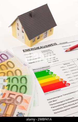 Un certificato energetico con una casa indipendente e banconote in euro Foto Stock