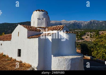 Chiesa di San Michele Arcangelo, chiesa a cupola a croce, chiesa bianca con cupola arrotondata su un imponente sfondo di montagna e cielo blu, Aradena Foto Stock