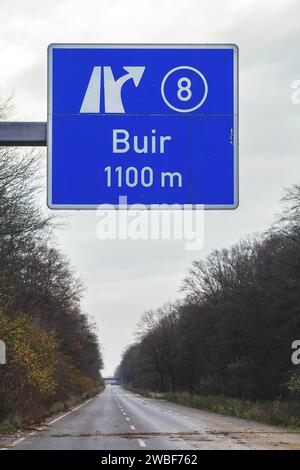 Un segnale stradale con una freccia direzionale indica l'uscita dell'autostrada Buir sotto un cielo blu, autostrada A4 abbandonata, Lost Place, Buir, Kerpen, nord Foto Stock