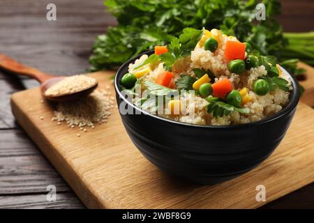 Delizioso porridge di quinoa con verdure in ciotola su tavolo di legno, primo piano Foto Stock