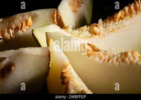 melone a fette su sfondo nero Foto Stock