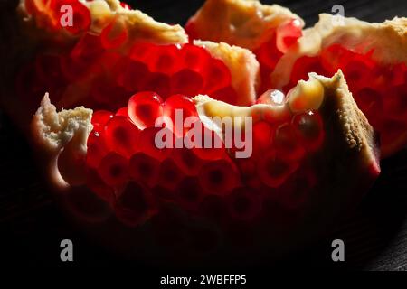 melograno affettato su sfondo nero Foto Stock