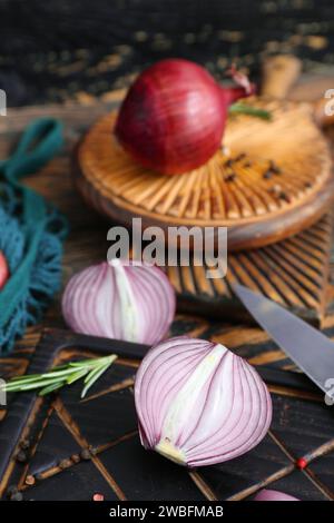 Tavole con cipolle rosse su fondo di legno marrone Foto Stock