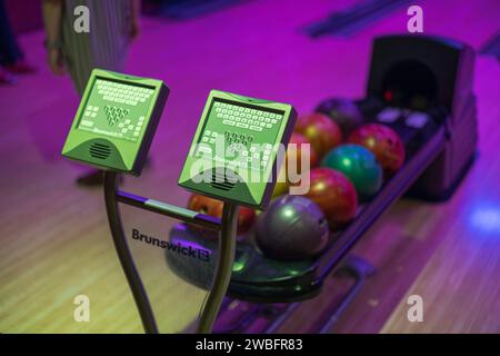 Vista colorata del rack e presentazione del nome del giocatore in un centro di bowling. Foto Stock