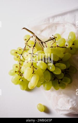 Uva Sultana in un sacchetto biodegradabile su fondo chiaro. Foto Stock