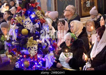 Non esclusiva: VINNYTSIA, UCRAINA - 6 GENNAIO 2024 - i devoti tengono bottiglie e candele accese presso la Cattedrale della Trasfigurazione del nostro Salvatore su Eiph Foto Stock