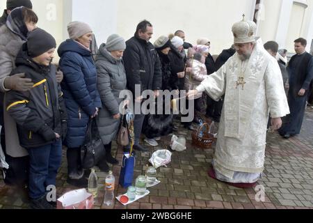 Non esclusiva: VINNYTSIA, UCRAINA - 6 GENNAIO 2024 - il metropolita di Vinnytsia e Bar Symeon (R) benedice la congregazione con acqua Santa fuori dal Foto Stock