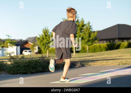 Un ragazzo sta giocando a hopscotch sull'asfalto nel parco giochi. Attività ricreative per bambini. Foto Stock