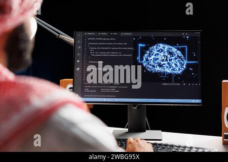 Immagine dettagliata di un uomo arabo che utilizza l'intelligenza artificiale e l'apprendimento automatico, garantendo la sicurezza informatica e sviluppando software per il computing. monitoraggio di una rete di sistemi interconnessi. Primo piano. Foto Stock