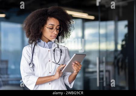 Medico specialista medico medico medico con un tablet digitale fornisce consulenza e assistenza specialistica al paziente. L'utilizzo della tecnologia per la comunicazione, la diagnosi, garantisce i risultati del servizio e dell'assistenza sanitaria Foto Stock