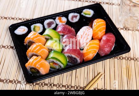 Set di nigiri sushi, uramaki e norimaki in vassoio di plastica Foto Stock