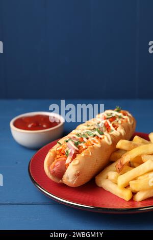 Delizioso hot dog con pancetta, carote e prezzemolo su un tavolo di legno blu Foto Stock