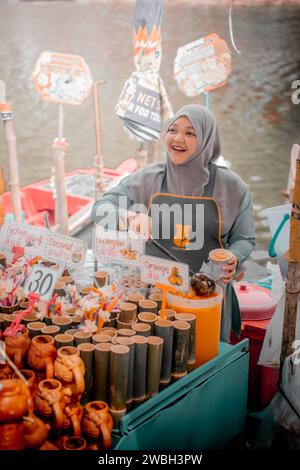 Hat Yai, Thailandia - 15 dicembre 2023: Una donna Hijab che vende una varietà di bevande al Khlong Hae Floating Market. Visita la Thailandia. Foto Stock
