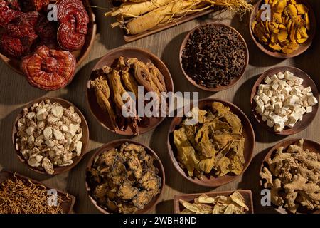 La vista dall'alto di un tavolo presentava molti tipi di medicina tradizionale cinese collocata su molti piatti di legno. Le erbe sono buone per la salute e possono migliorare lui Foto Stock