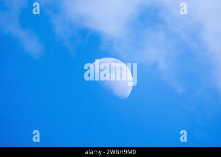 La Luna è nel cielo nuvoloso blu in una foto naturale di giorno Foto Stock