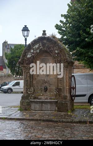 La Fontaine Notre-Dame, un'antica fontana in pietra con una ruota laterale all'esterno dell'Église Notre-Dame-de-l'Assomption in Place Notre Dame, una piazza della città Foto Stock