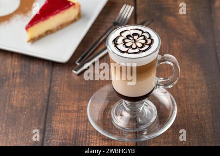 Caffè a più strati in tazza di vetro su un tavolo di legno Foto Stock