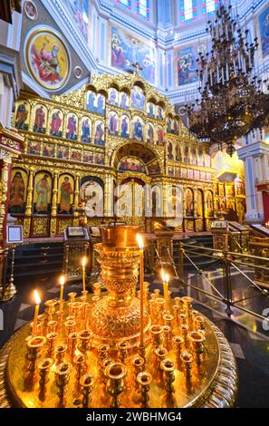 Alcune candele commemorative sono accese con l'altare d'oro riccamente dipinto sullo sfondo. Presso l'Ascensione, la cattedrale di legno Zenkov nel parco Panfilov. Ad Alma Foto Stock