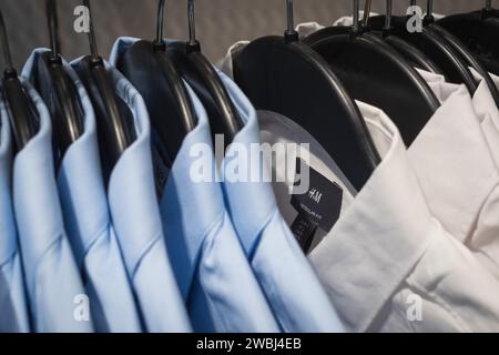 Bangkok, Thailandia - 10 dicembre 2023: Magliette H&M (con l'etichetta) appese a un rack in un negozio. Foto Stock