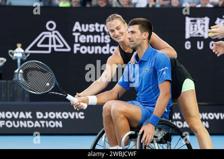 11 gennaio 2024: Aryna Sabalenka aiuta Novak Djokovic a giocare a tennis su una sedia a rotelle sulla Rod Laver Arena in un evento di beneficenza per l'Australian Tennis Foundation prima dell'Australian Open che inizia il 14 gennaio. Sydney Low/Cal Sport Media Foto Stock