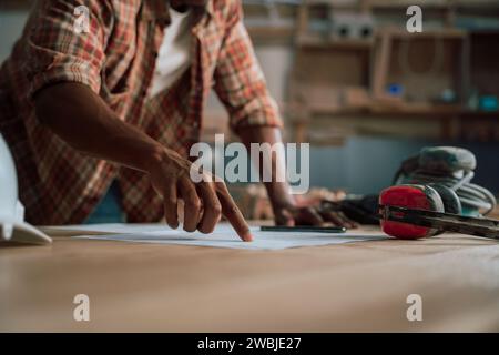 Il giovane African An sta lavorando al suo piano di costruzione nella sua fabbrica Foto Stock