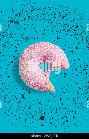 Una ciambella rosa morsa con spruzzi bianchi su sfondo blu. Ciambella fresca versata con glassa rosa. Foto Stock