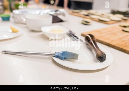 pennello culinario con olio sul piatto, utensili da cucina. Foto Stock