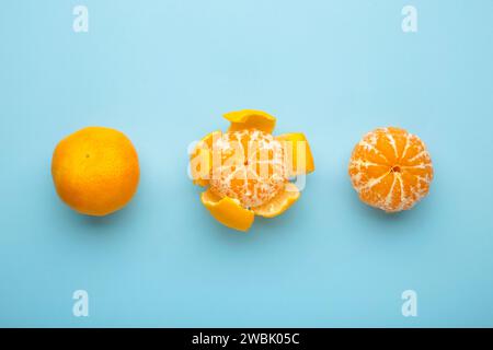 mandarino fresco sbucciato su sfondo blu. Vista dall'alto. Foto Stock