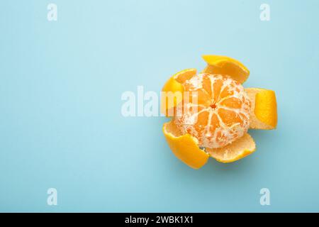 mandarino fresco sbucciato su sfondo blu. Vista dall'alto. Foto Stock