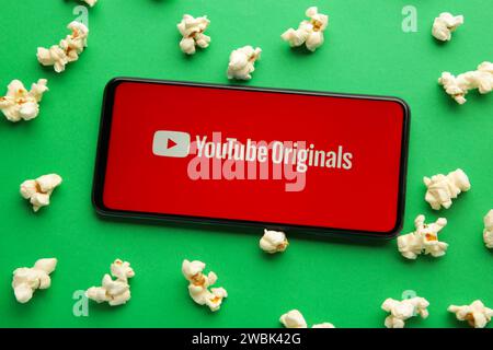 Nikolaev, Ucraina - 20 novembre 2021: Popcorn e logo YouTube su smartphone su sfondo verde. Vista dall'alto Foto Stock