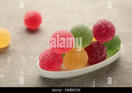 Palline di marmellata in un recipiente di vetro su sfondo grigio. Vista dall'alto Foto Stock
